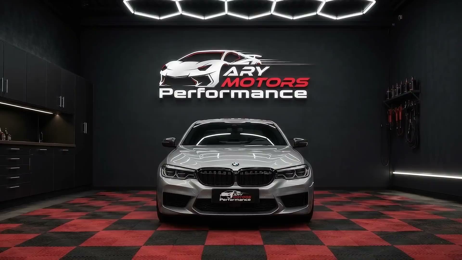 Silver BMW under hexagon lights on the red and black chequered floor at ARY Motors Performance in Birmingham